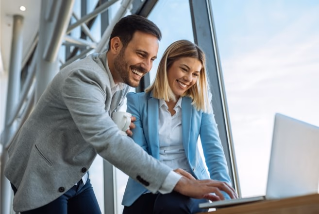 Ein Mann und eine Frau schauen auf einen Laptop