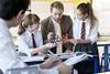 An image showing a teacher explaining chemistry concepts with the help of a molecular model to his students