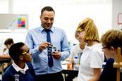 A group of students with a teacher in a school laboratory and classroom