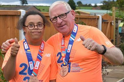 Stephen and his son, Michael, are giving the thumbs up at the camera. Both are wearing London Marathon finisher T-shirts and medals. 