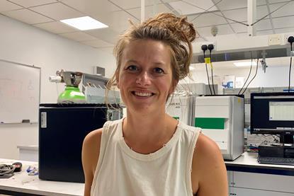 Emma Withers in a laboratory smiling. 