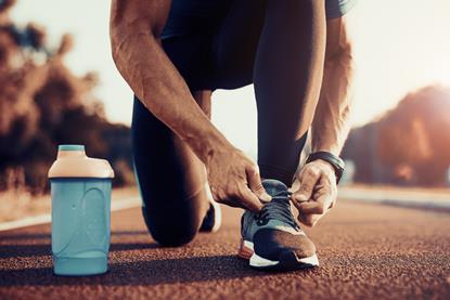 An image showing an athlete tied his shoelaces before starting his marathon training