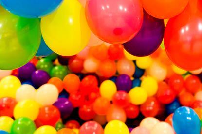 Balloons of many different colours and sizes filling a room