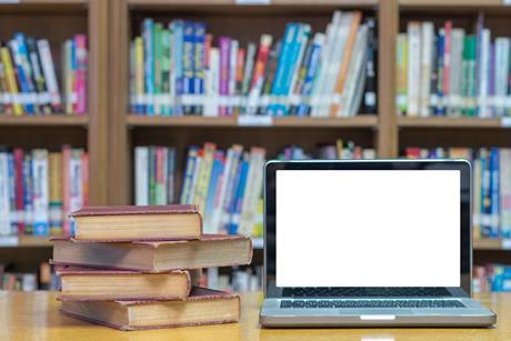 Laptop and books in library