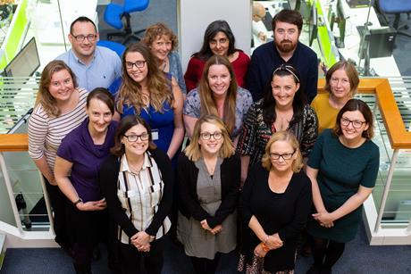 A group of education coordinators pose for a group photograph on a staircase in the Royal Society of Chemistry offices