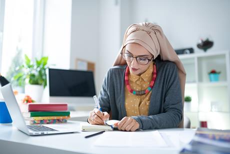 Female primary school teacher works at her desk