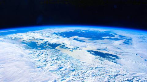 A photo of the Earth from orbit showing the thin blue atmosphere and white clouds