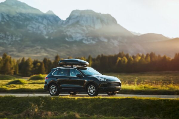 suv driving on the road with mountains in the background