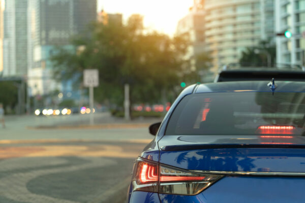 Miami street traffic with driving cars at urban intersection in Florida