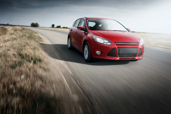 red ford focus driving on a road