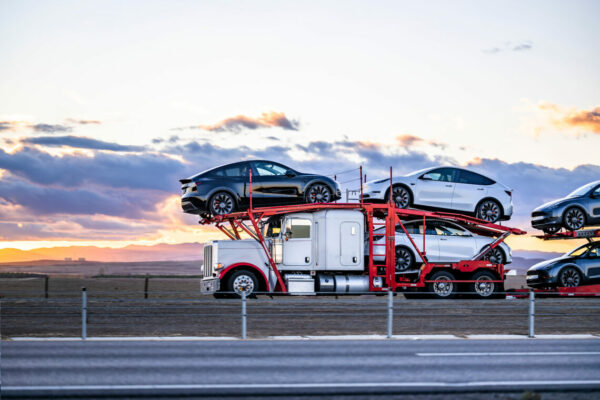 hauler semi truck transporting cars on the hydraulic semi trailer driving on the road at twilight