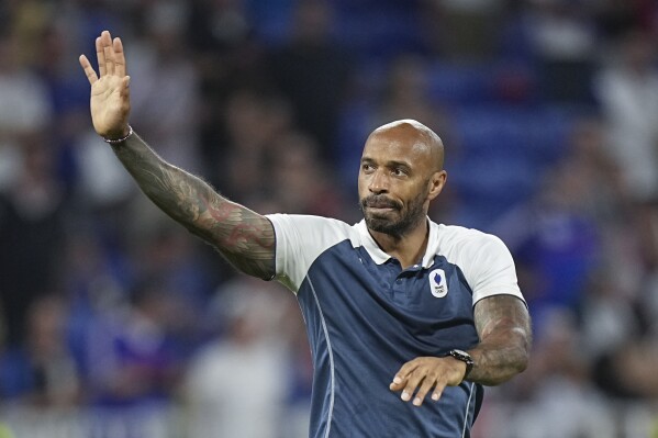 France's head coach Thierry Henry waves to fans as he celebrates his team's victory over Egypt at the end of the men's semifinal soccer match at Lyon Stadium, during the 2024 Summer Olympics, Monday, Aug. 5, 2024, in Decines, France.(AP Photo/Laurent Cipriani)