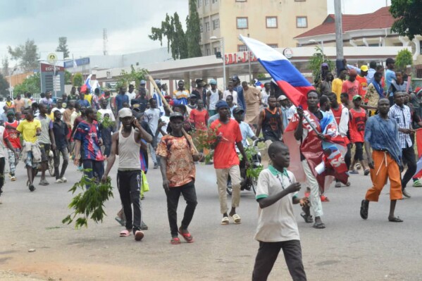 People wave Russian flags during a protest in Kaduna, Nigeria, Monday, Aug 5, 2024. (AP Photo/Mohammed Ibrahim)