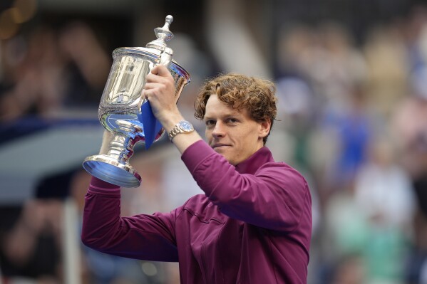 Jannik Sinner, of Italy, holds up the championship trophy after defeating Taylor Fritz, of the United States, in the men's singles final of the U.S. Open tennis championships, Sunday, Sept. 8, 2024, in New York. (AP Photo/Seth Wenig)