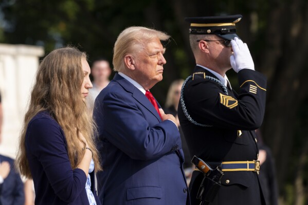 Misty Fuoco, left, sister of Nicole Gee, and Republican presidential nominee former President Donald Trump place their hands over their heart after placing a wreath in honor of Sgt. Nicole Gee, at the Tomb of the Unknown Solider at Arlington National Cemetery, Monday, Aug. 26, 2024, in Arlington, Va. (AP Photo/Alex Brandon)