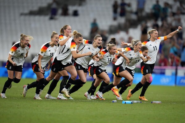 Germany players celebrate after wining a women's quarterfinal soccer match against Canada at the 2024 Summer Olympics, Saturday, Aug. 3, 2024, at Marseille Stadium in Marseille, France. (AP Photo/Julio Cortez)