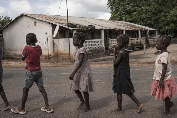 Children walk on the streets in Sintet, Gambia, Friday, July. 26, 2024. Gambia has been rocked in recent months by a heated debate on female genital cutting, a centuries-old practice rooted in concepts about sexual purity and control of women. (AP Photo/Annika Hammerschlag)