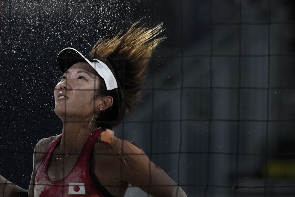 Japan's Miki Ishii eyes the ball during the women's pool E beach volleyball match between Netherlands and Japan at Eiffel Tower Stadium at the 2024 Summer Olympics, Tuesday, July 30, 2024, in Paris, France. (AP Photo/Louise Delmotte)