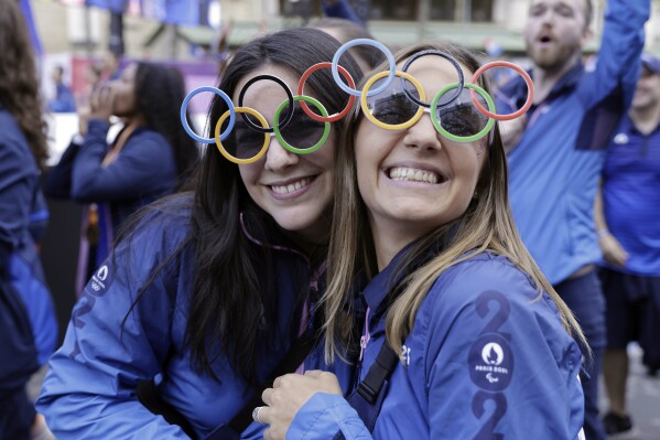 Volunteers of Paris 2024 Olympics and French athletes who participated in the 2024 Olympics and Paralympics take part in a parade in front of the Arc de Triomphe monument on the Champs Elysees, Saturday, Sept. 14, 2024 in Paris. (Andre Pain/Pool Photo via AP)