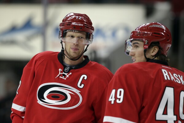 FILE - Carolina Hurricanes' Eric Staal (12) speaks with Victor Rask (49) during the first period of an NHL hockey game against the Boston Bruins in Raleigh, N.C., Friday, Feb. 26, 2016. NHL veteran Eric Staal is retiring after an 18-year career in the league. (AP Photo/Gerry Broome, File)