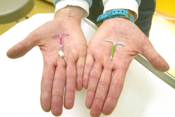 FILE - Dr. Susan Gorman displays the Skyla IUD, left, and the Mirena IUD, at High Lakes Gynecology in Redmond, Ore., Jan. 14, 2015. (Andy Tullis/The Bulletin via AP)