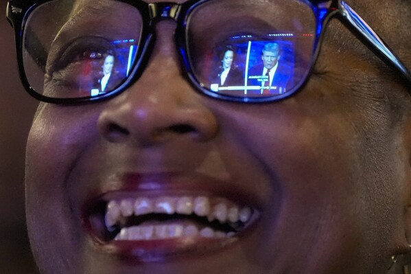 Sheena Carey laughs as she watches the presidential debate between Republican presidential nominee former President Donald Trump and Democratic presidential nominee Vice President Kamala Harris, Tuesday, Sept. 10, 2024, in Milwaukee. (AP Photo/Morry Gash)