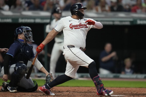 Cleveland Guardians' Josh Naylor, right, hits a single in front of Tampa Bay Rays catcher Logan Driscoll, left, in the sixth inning of a baseball game Saturday, Sept. 14, 2024, in Cleveland. (AP Photo/Sue Ogrocki)