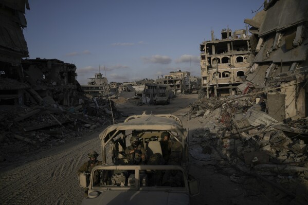 Israeli soldiers move next to buildings destroyed by the Israeli military in the Gaza Strip on Friday, Sept. 13, 2024. (AP Photo/Leo Correa)