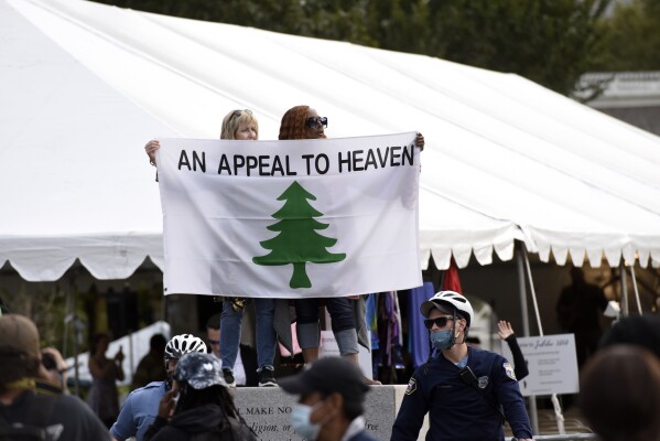 FILE - People carry an "Appeal To Heaven" flag as they gather at Independence Mall to support President Donald Trump during a visit to the National Constitution Center to participate in the ABC News town hall, Sept. 15, 2020, in Philadelphia. Supreme Court Justice Samuel Alito is embroiled in a second flag controversy, this time over the “Appeal to Heaven” flag, a banner that in recent years has come to symbolize Christian nationalism and the false claim that the 2020 presidential election was stolen. The flag was seen outside his New Jersey beach home last summer. (AP Photo/Michael Perez, File)