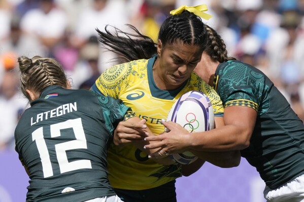 Australia's Sarah Maki is tackled by South Africa's Liske Lategan, left, during the women's Pool B Rugby Sevens match between Australia and South Africa at the 2024 Summer Olympics, in the Stade de France, in Saint-Denis, France, Sunday, July 28, 2024. (AP Photo/Tsvangirayi Mukwazhi)