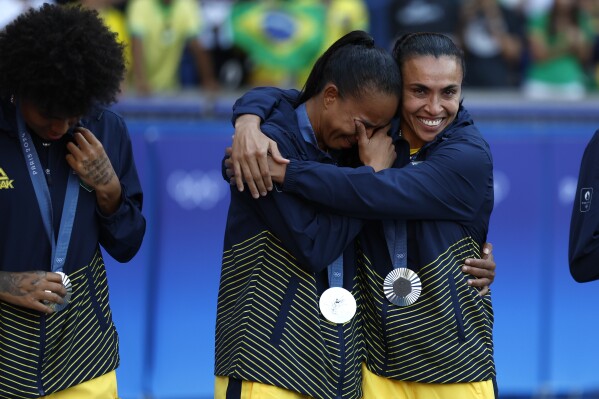 Brazil's Marta, right, consoles a teammate during the medal ceremony after the women's soccer gold medal match between Brazil and the United States at the Parc des Princes during the 2024 Summer Olympics, Saturday, Aug. 10, 2024, in Paris, France. (AP Photo/Aurelien Morissard)