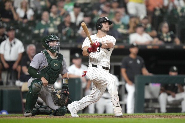 Chicago White Sox's Andrew Benintendi watches with Oakland Athletics catcher Shea Langeliers, Benintendi's game winning home run off relief pitcher Hogan Harris in during the ninth inning of a baseball game Saturday, Sept. 14, 2024, in Chicago. The White Sox won 7-6 . (AP Photo/Charles Rex Arbogast)