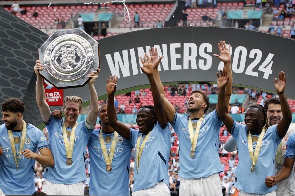 Manchester City midfielder Kevin De Bruyne lifts the trophy after his team won the FA Community Shield soccer match between Manchester City and Manchester United at Wembley Stadium in London, Saturday, Aug. 10, 2024. (AP Photo/David Cliff)