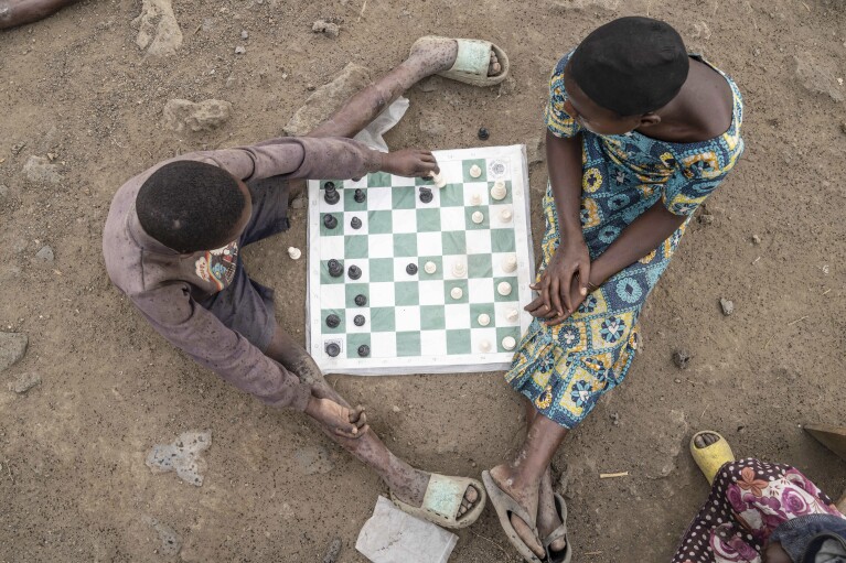 Children play a chess game at 'The Soga Chess Club' of the internally displaced persons camp in Kanyaruchinya, Democratic Republic of Congo, Monday, July 29, 2024. (AP Photo/Moses Sawasawa)