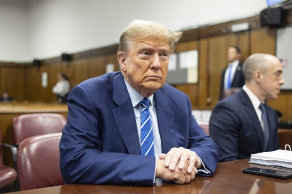 FILE - Former President Donald Trump awaits the start of proceedings on the second day of jury selection at Manhattan criminal court, April 16, 2024, in New York. Manhattan prosecutors are balking at Donald Trump efforts to delay post-trial decisions in his New York hush money criminal case as he seeks to have a federal court intervene and potentially overturn his felony conviction. They lodged their objections in a letter Tuesday to the trial judge but said they could be OK with postponing the ex-president’s Sept. 18 sentencing. (Justin Lane/Pool Photo via AP)