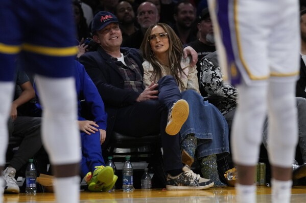 FILE - Ben Affleck and Jennifer Lopez watch an NBA basketball game between the Golden State Warriors and the Los Angeles Lakers in Los Angeles, March 16, 2024. (AP Photo/Ashley Landis, File)