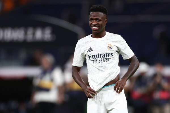 Real Madrid's Vinicius Junior smiles before the Spanish La Liga soccer match between Real Madrid and Betis at the Santiago Bernabeu stadium in Madrid, Spain, Sunday, Sept. 1, 2024. (AP Photo/Pablo Garcia)