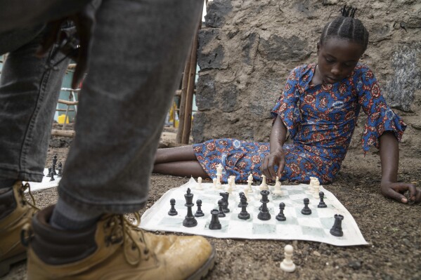 13 year-old Arusi Wegeneza plays a chess game at 'The Soga Chess Club' of the internally displaced persons camp in Kanyaruchinya, Democratic Republic of Congo, Monday, July 29, 2024. (AP Photo/Moses Sawasawa)