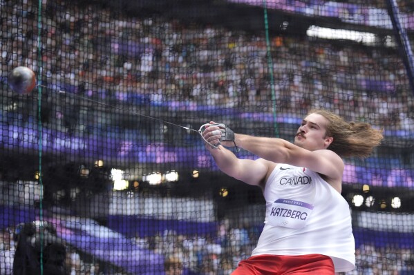 Ethan Katzberg, of Canada, makes an attempt in the men's hammer throw qualification at the 2024 Summer Olympics, Friday, Aug. 2, 2024, in Saint-Denis, France. (AP Photo/Matthias Schrader)