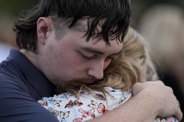 Mourners pray during a candlelight vigil for the slain students and teachers at Apalachee High School, Wednesday, Sept. 4, 2024, in Winder, Ga. (AP Photo/Mike Stewart)