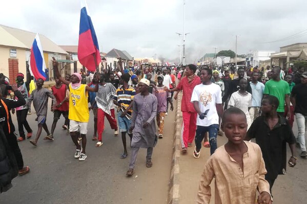 People wave Russian flags during a protest in Kaduna, Nigeria, Monday, Aug 5, 2024. (AP Photo/Mohammed Ibrahim)