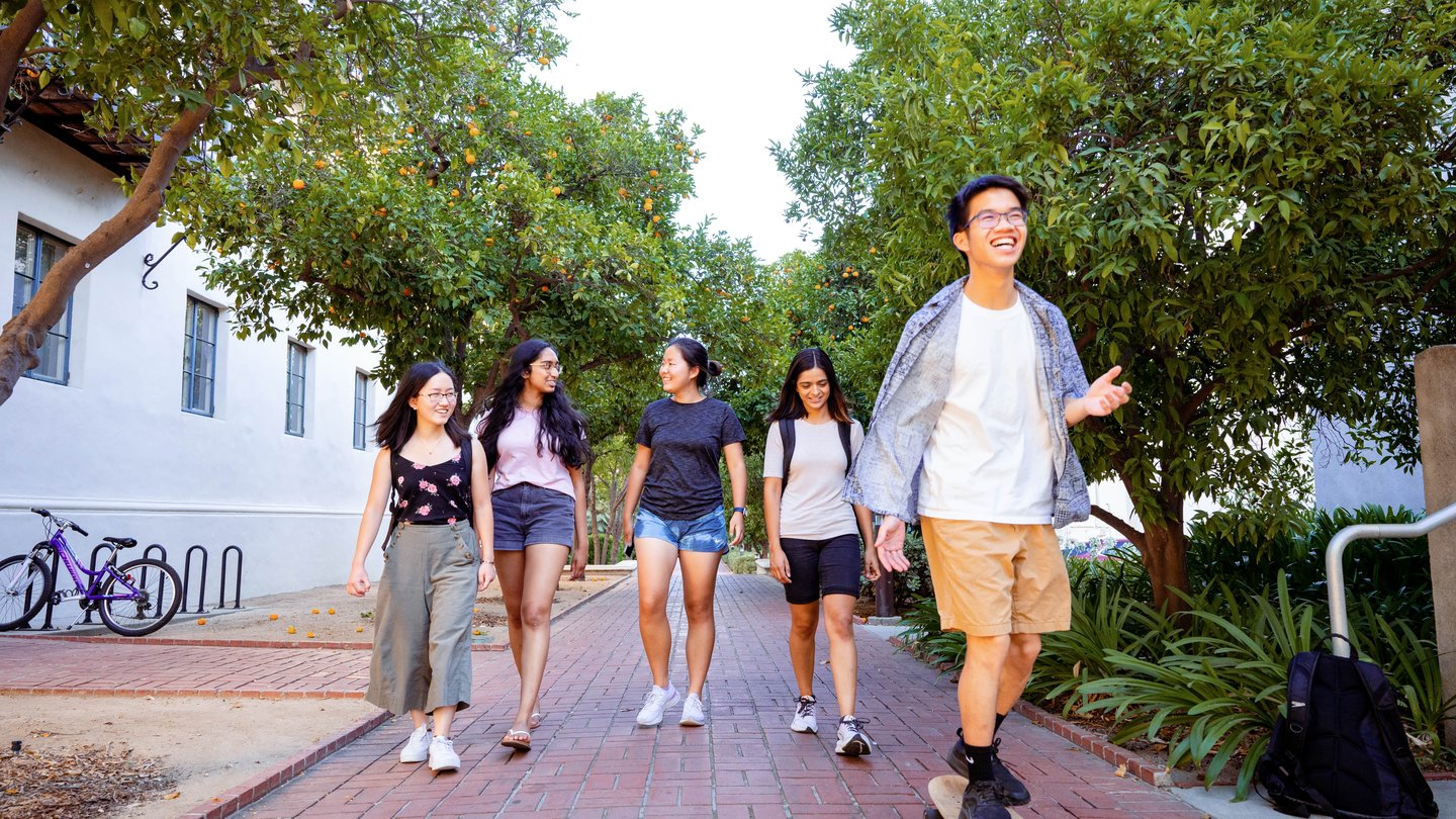 group of four students walking on campus