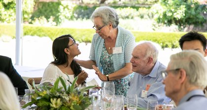 Older woman talking to another woman sitting down