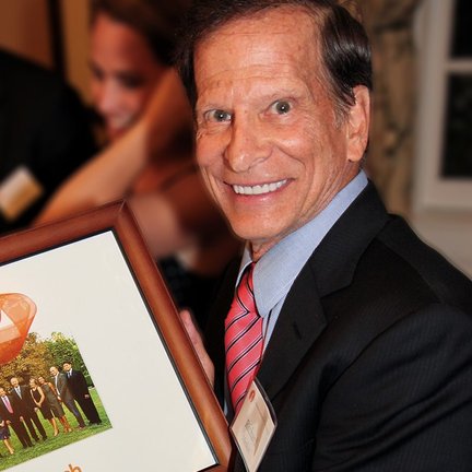 Richar Merkin holding a framed photo