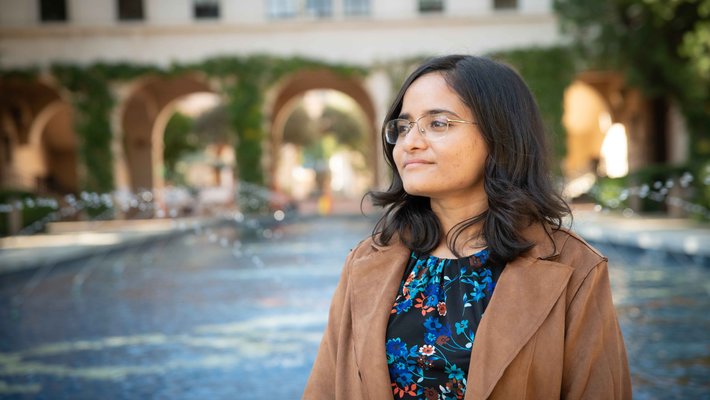 Person looking into the distance with a fountain in the background