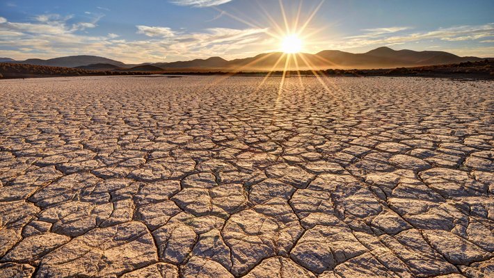 A desert with a sunrise above