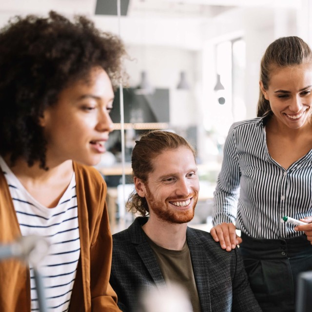 Four coworkers standing around a computer