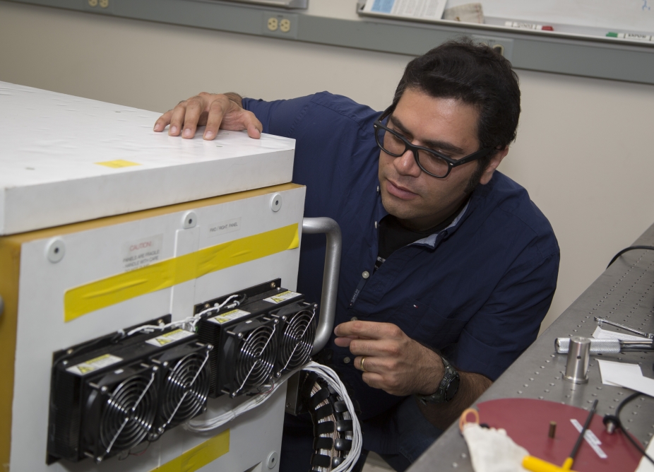 Postdoctoral student works on a scientific instrument