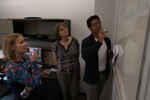 SOARS Protégé reviewing an equation on a whiteboard with his mentors