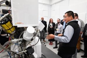 A tour guide shows a tour group one of the pieces of equipment at the MCP